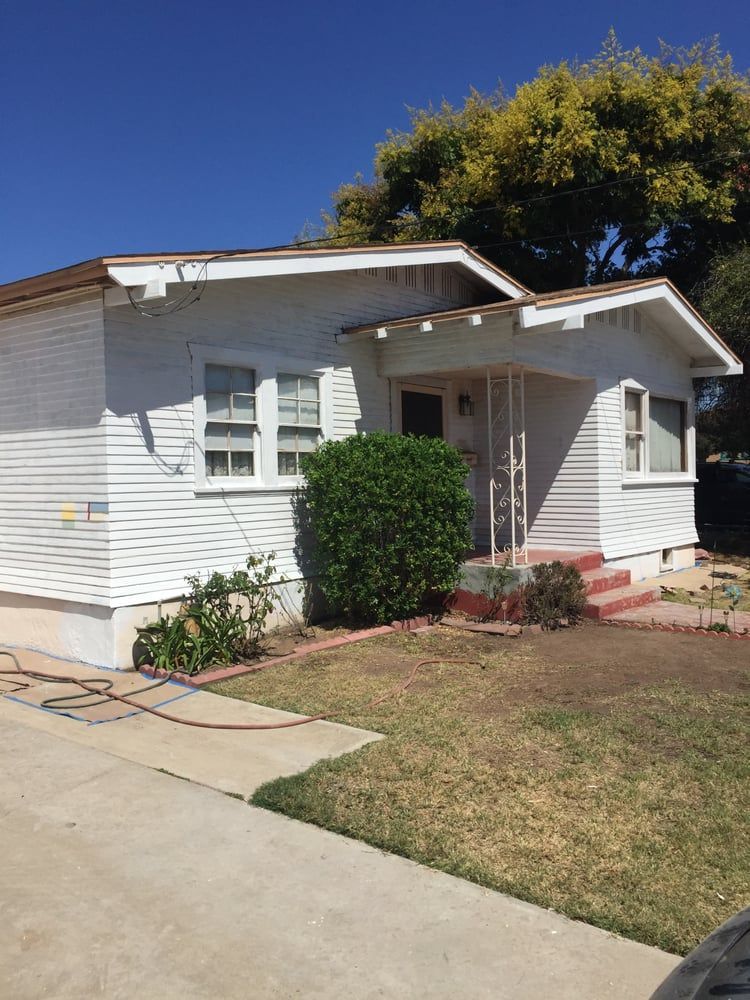 A white house with a hose in front of it