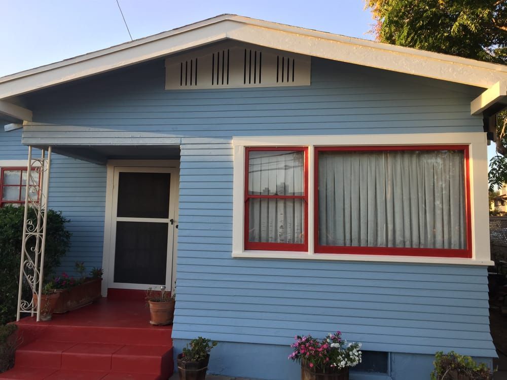 A blue house with red windows and white trim