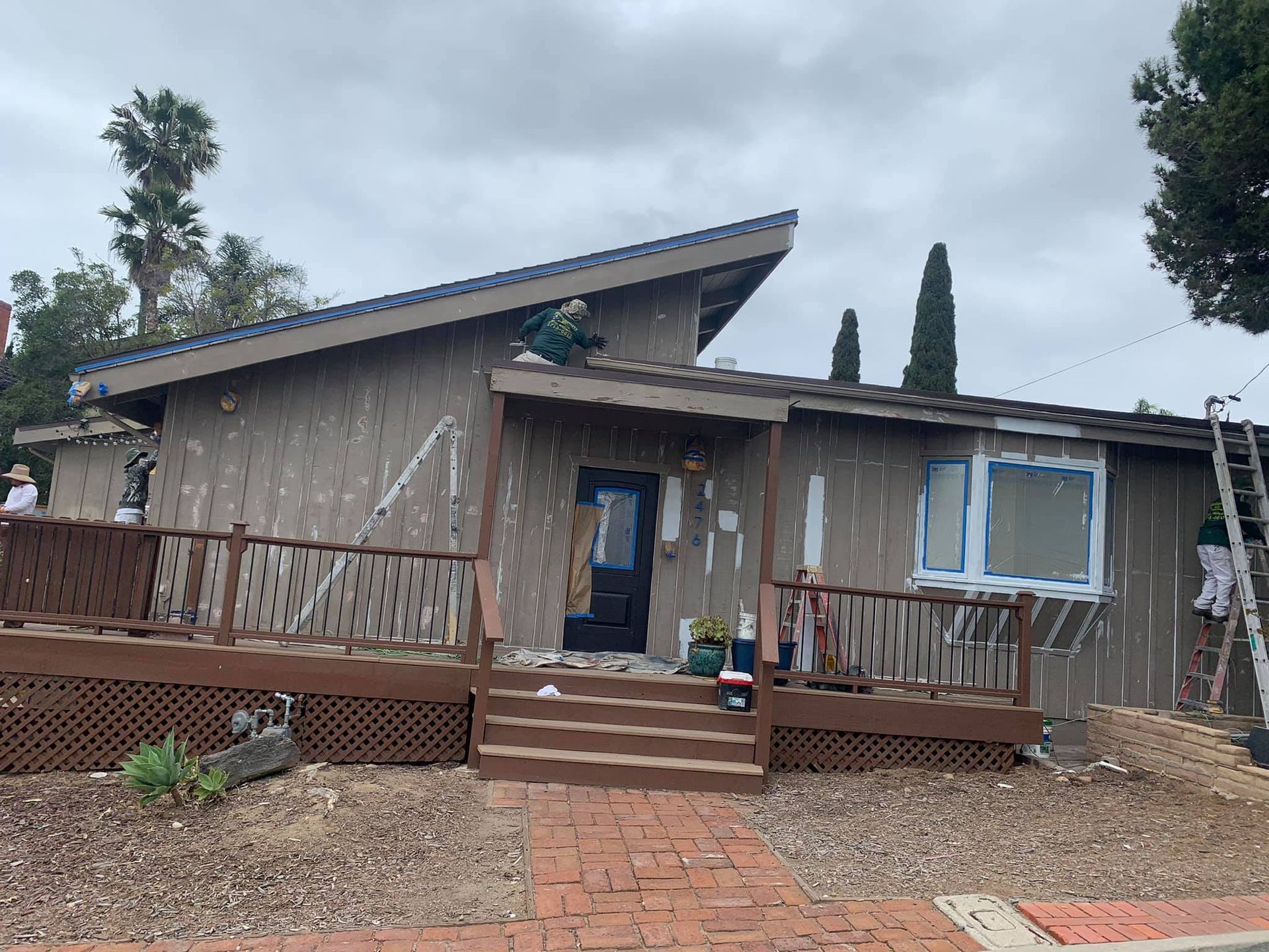 A house is being painted with a ladder in front of it.