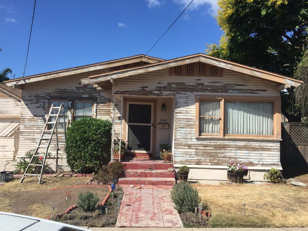 A white house with a ladder in front of it