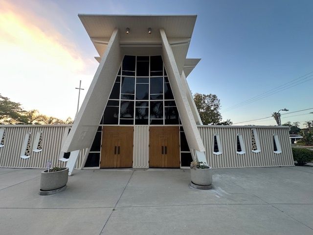 The front of a church with a cross in the background