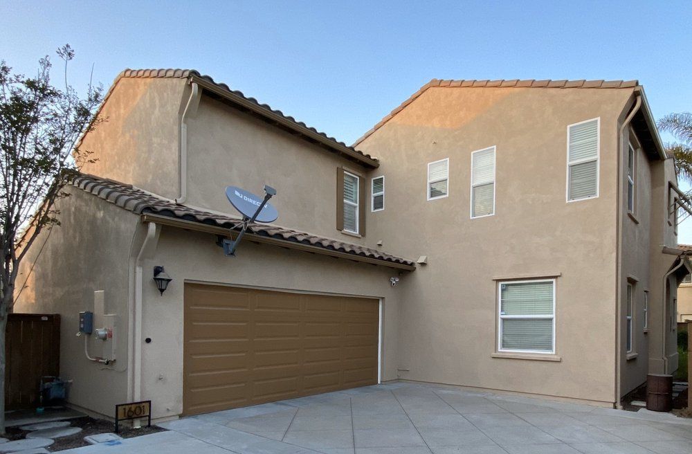 A house with a garage and a satellite dish on the roof
