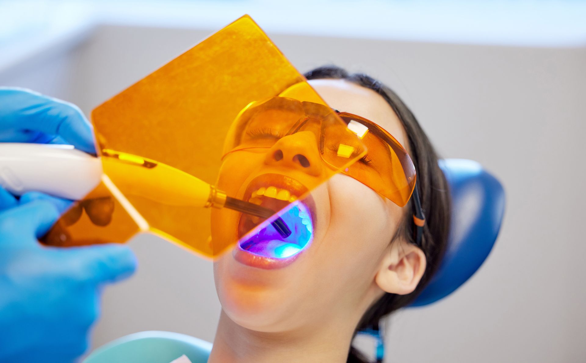 A woman is getting her teeth examined by a dentist.