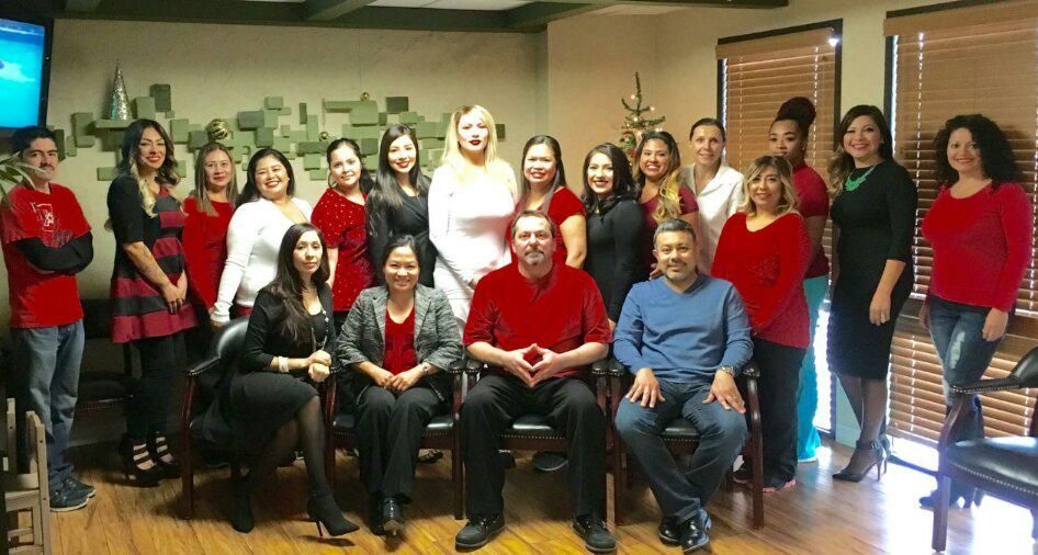 A group of people, mostly women, posing for a photo indoors. Many wear red clothing.