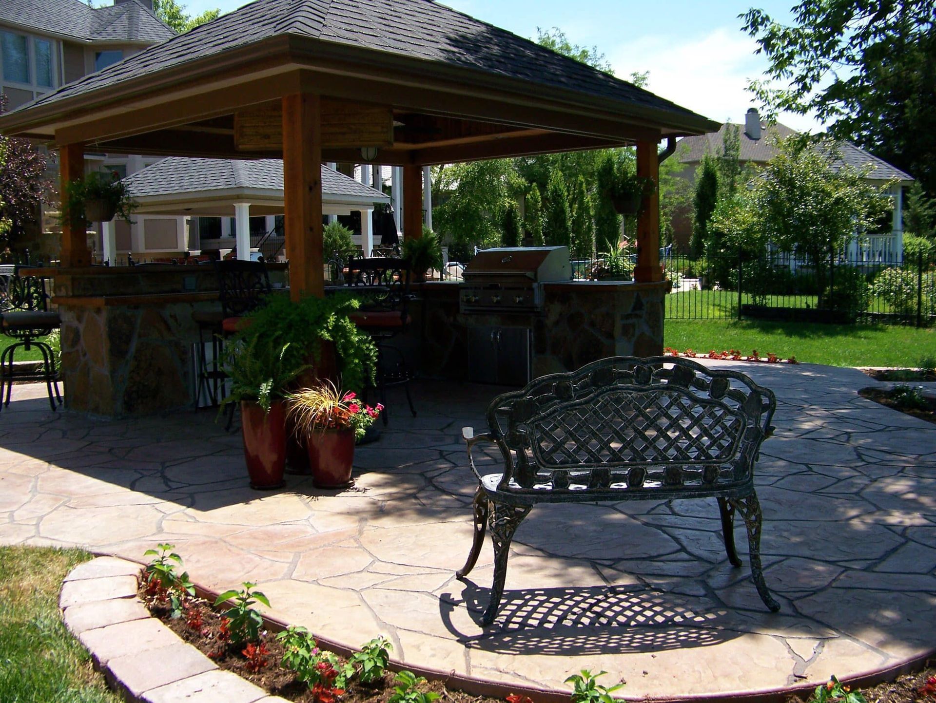 A gazebo with a bench in front of it