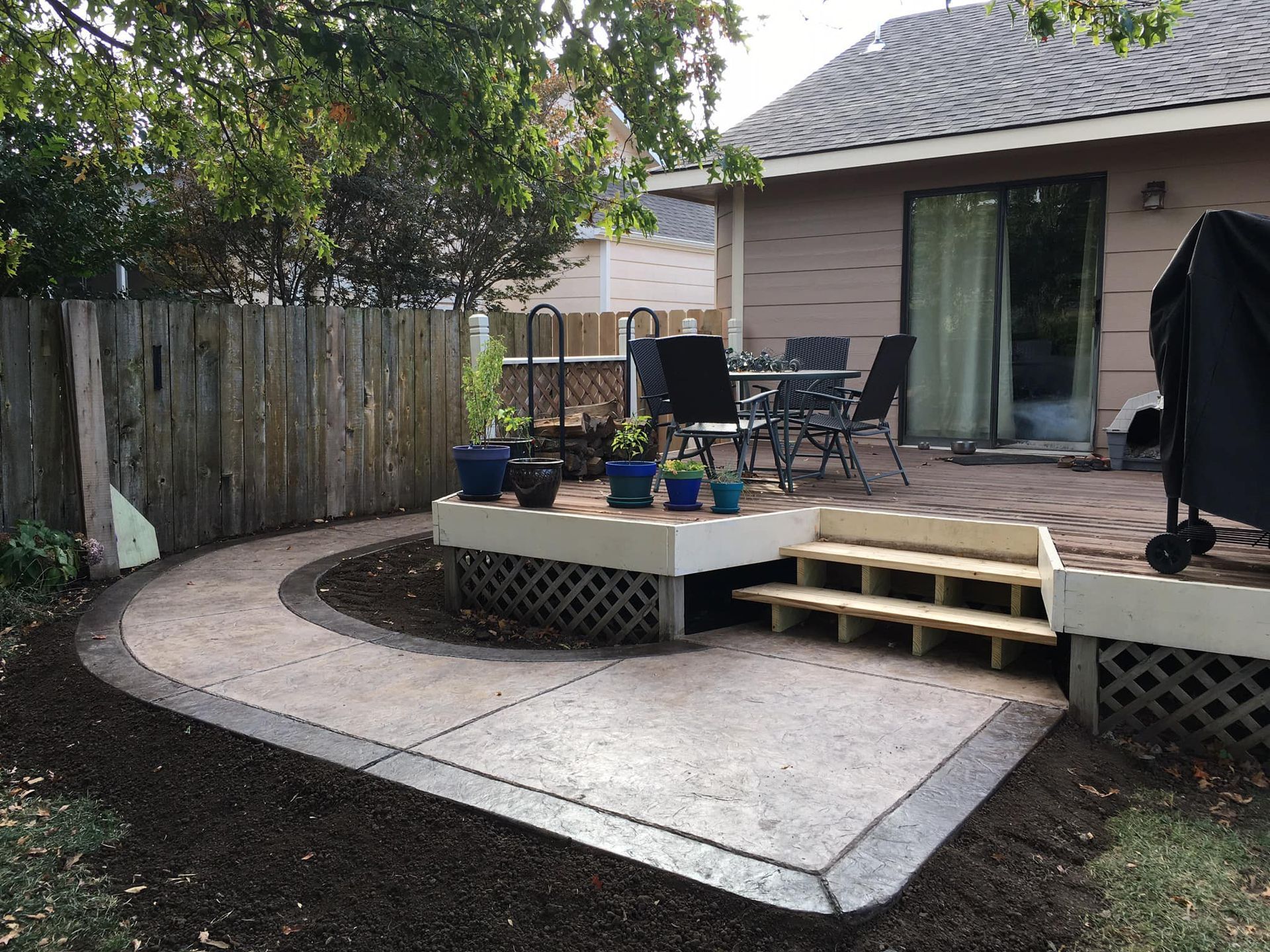 A patio with a table and chairs in front of a house.