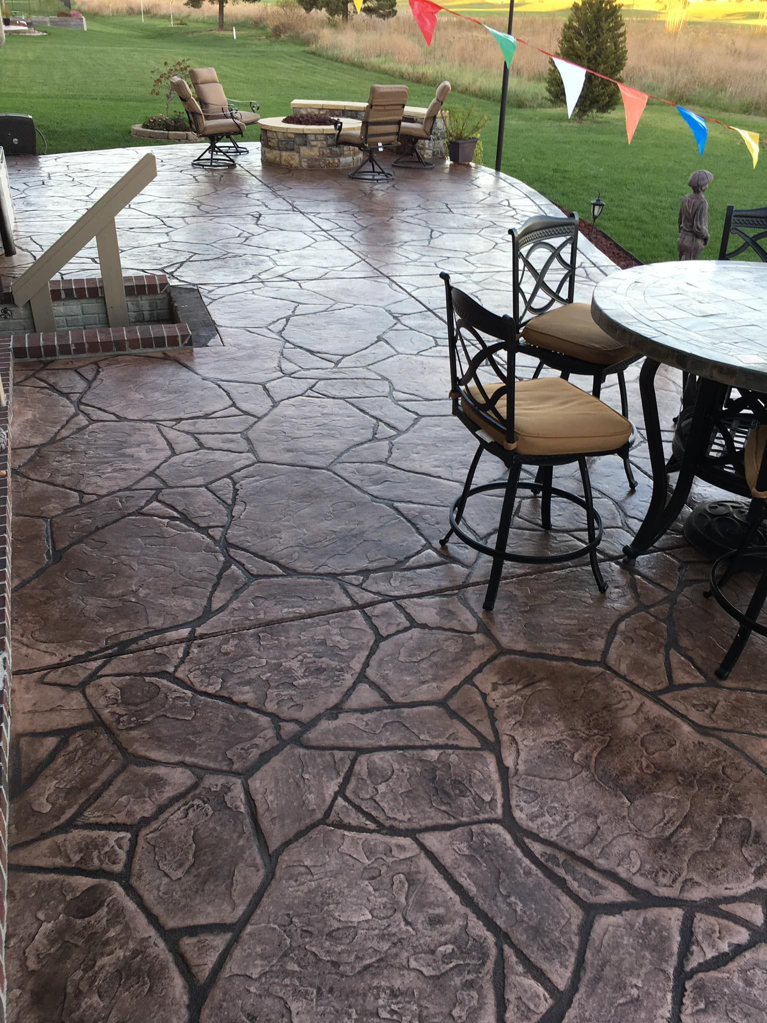 A patio with a table and chairs and a fire pit.