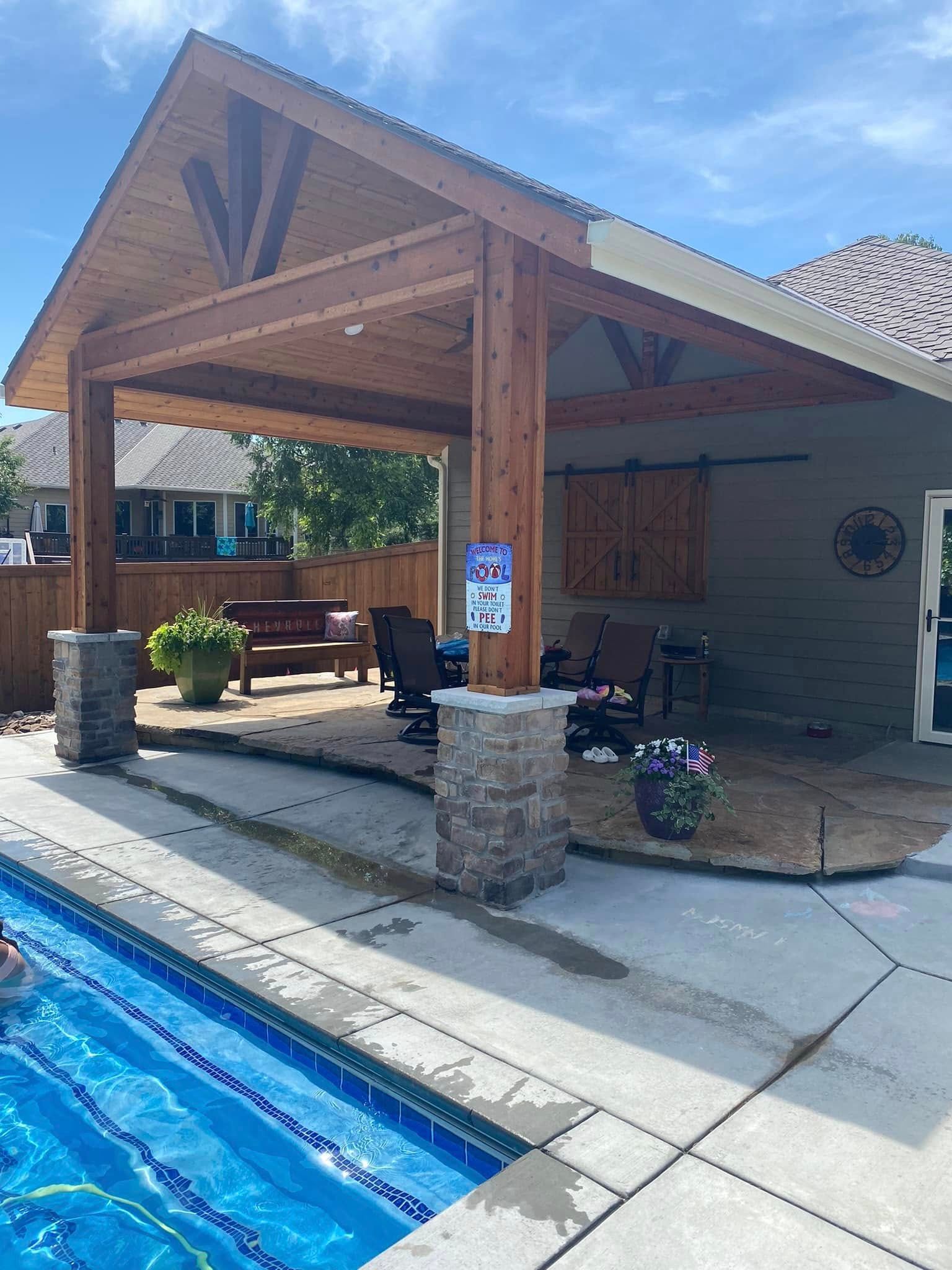 There is a covered patio area next to a swimming pool.