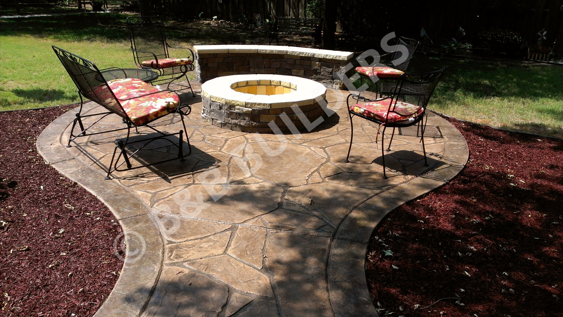 Stamped concrete seating area with masonry firepit and sitting wall