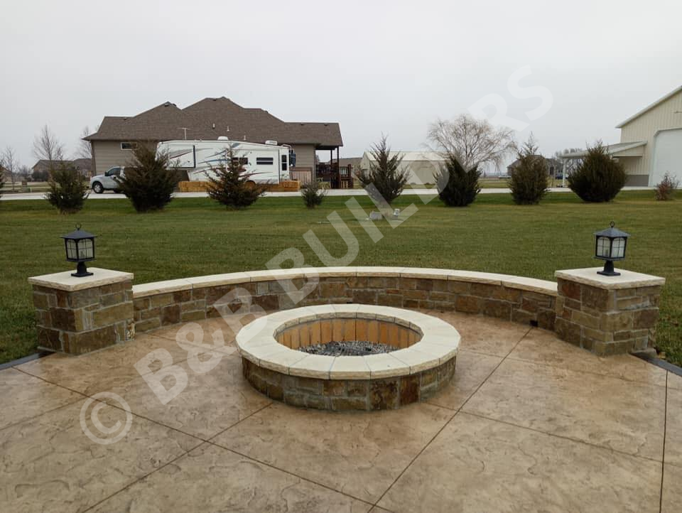 Concrete deck with round masonry firepit and round sitting wall with lanterns on each end