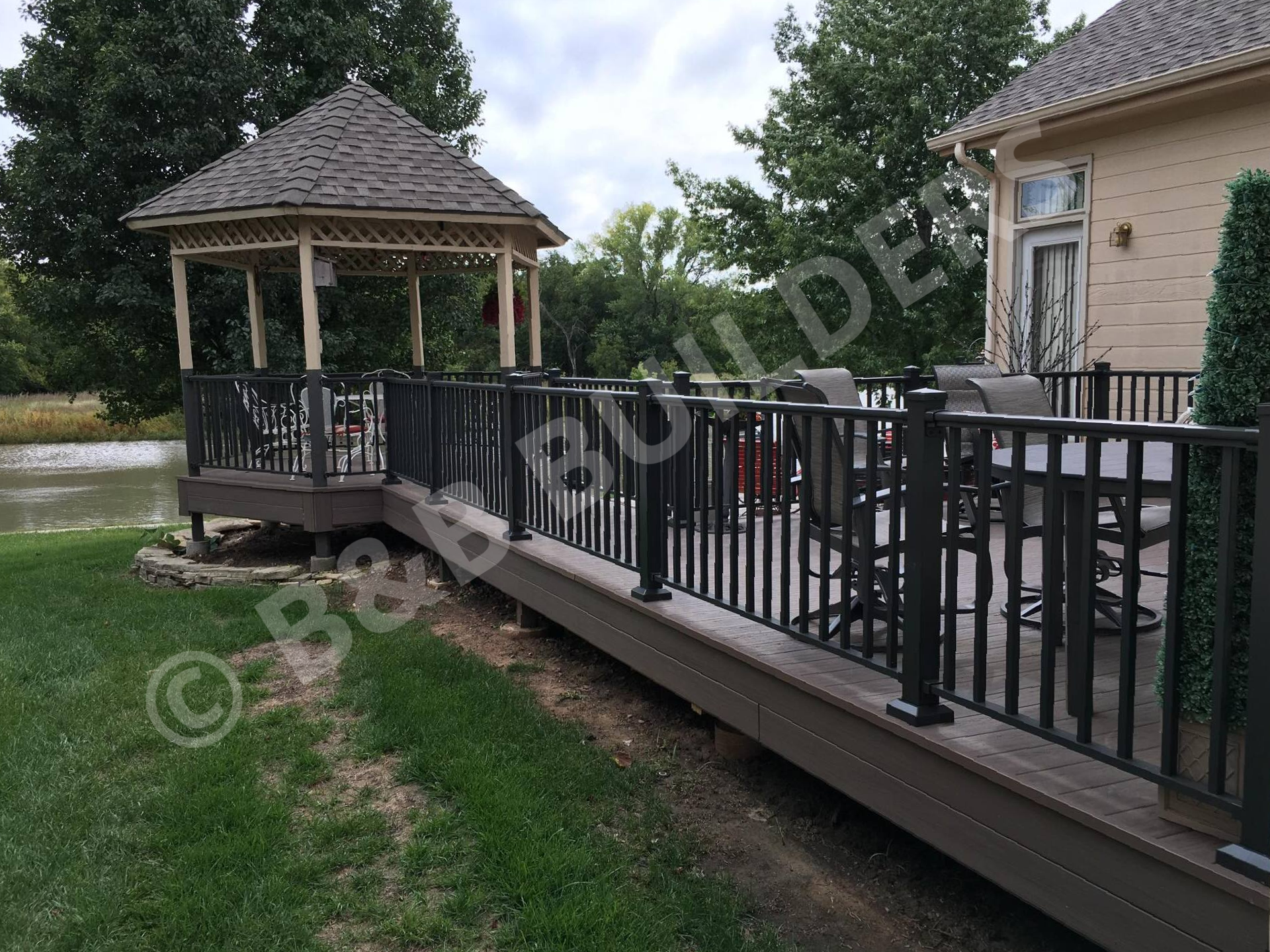 Wooden gazebo with composite deck and metal railing