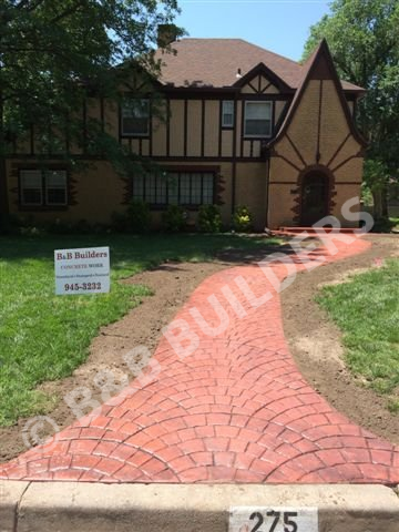 A  stamped concrete red curved entryway
