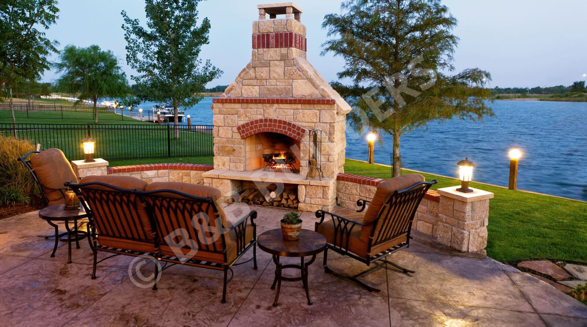 Lakeside concrete patio with masonry firpelace and seating area