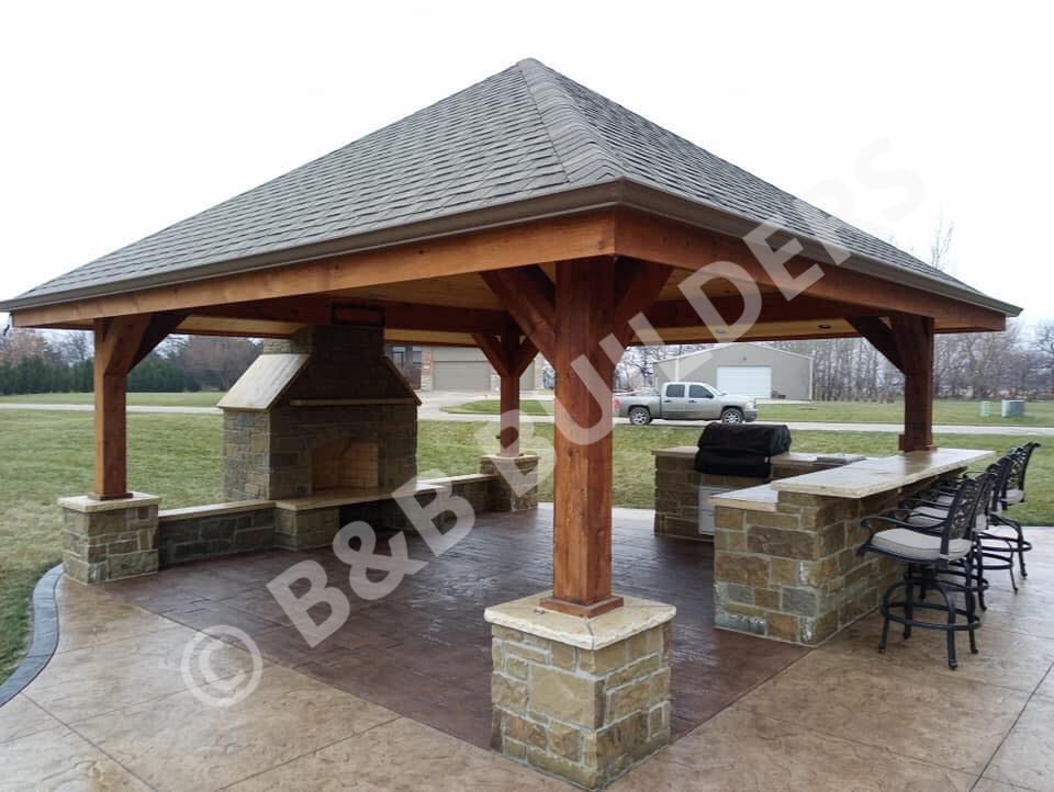 Stamped concrete patio with roof, stone fireplace, and outdoor kitchen