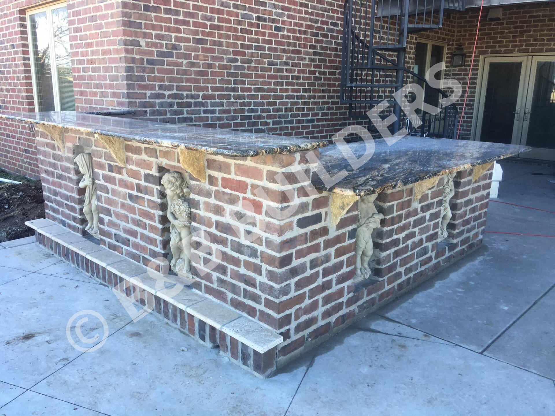 Two level brick outdoor bar with marble tops and inset statues