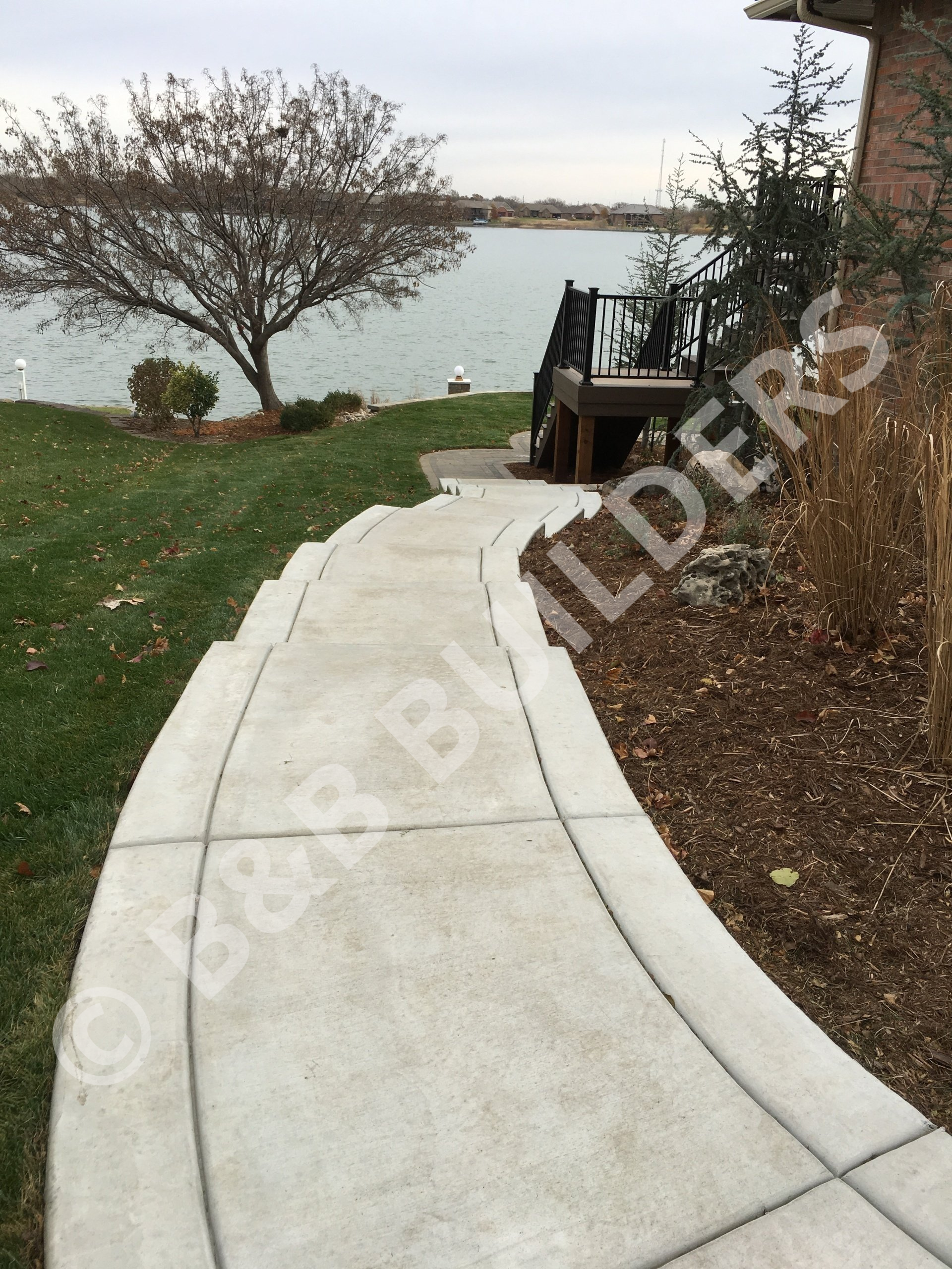 A curved concrete path with decorative lines and stairs