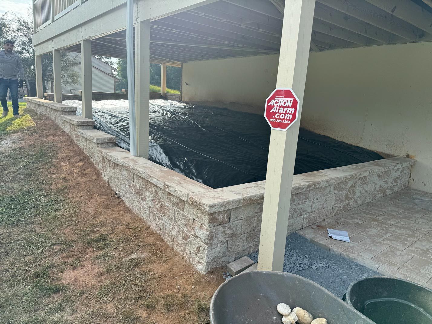 A man is standing next to a stop sign in front of a house.