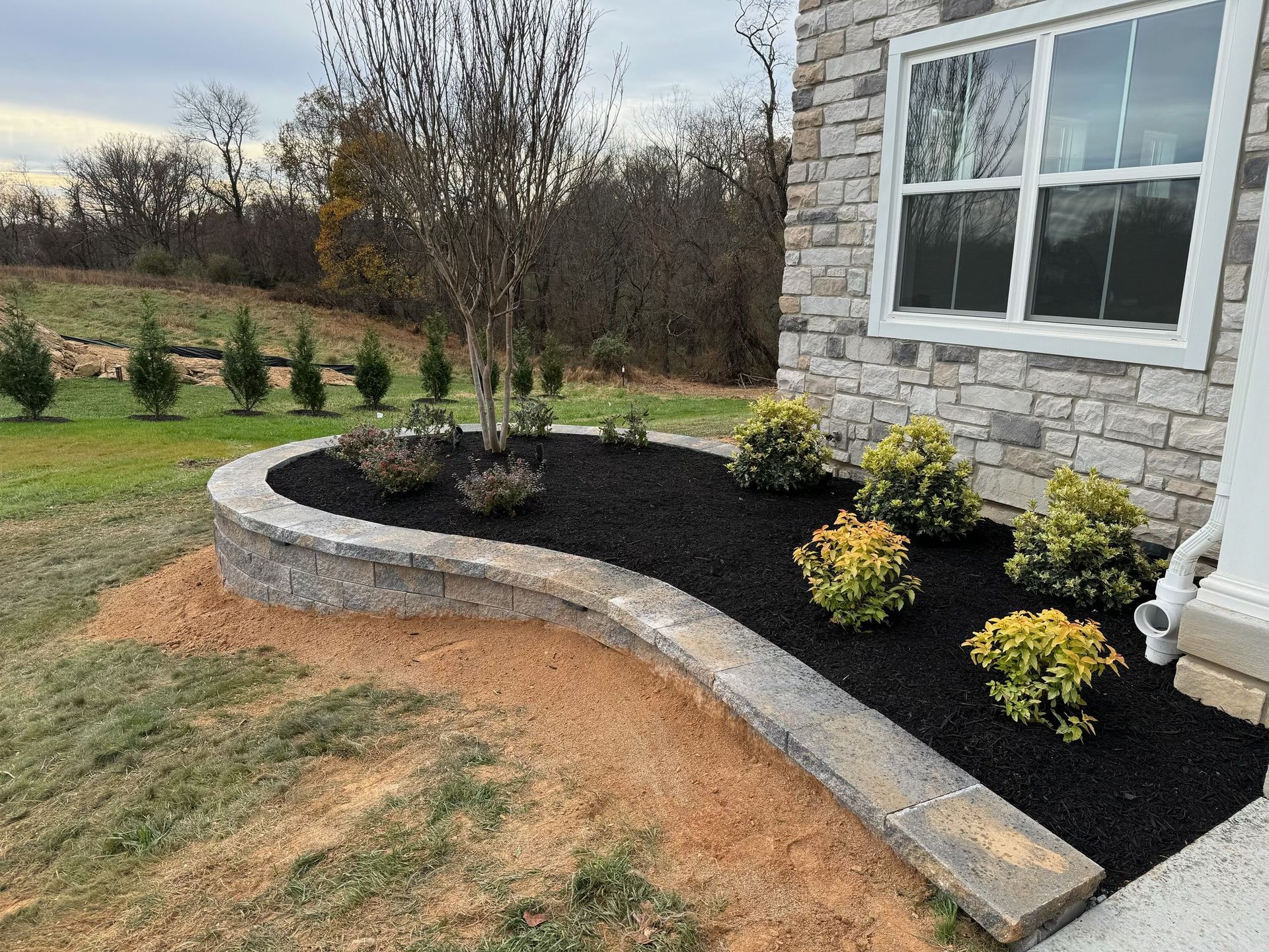 A brick house with a garden in front of it.