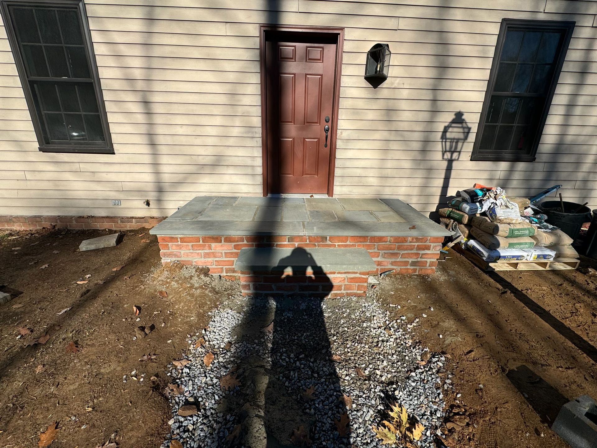 A brick porch is being built in front of a house