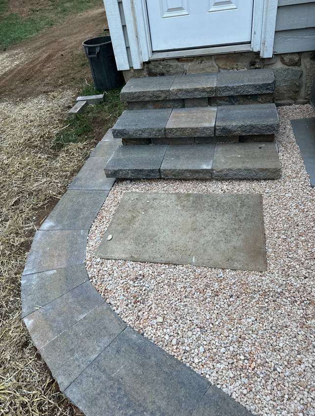 A stone walkway with steps leading up to a house