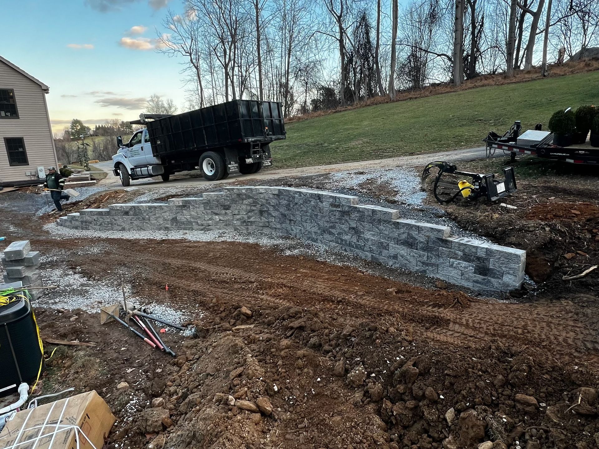 A dump truck is parked on the side of a dirt road.