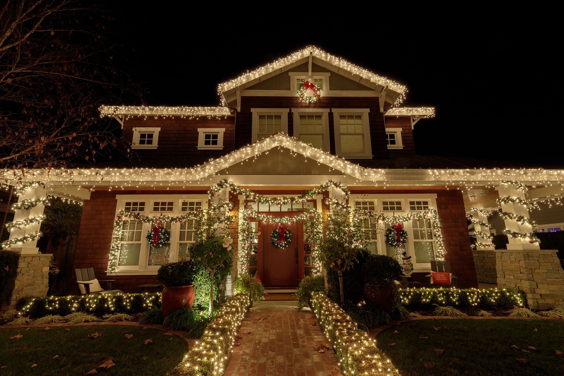 A house is decorated with christmas lights and wreaths