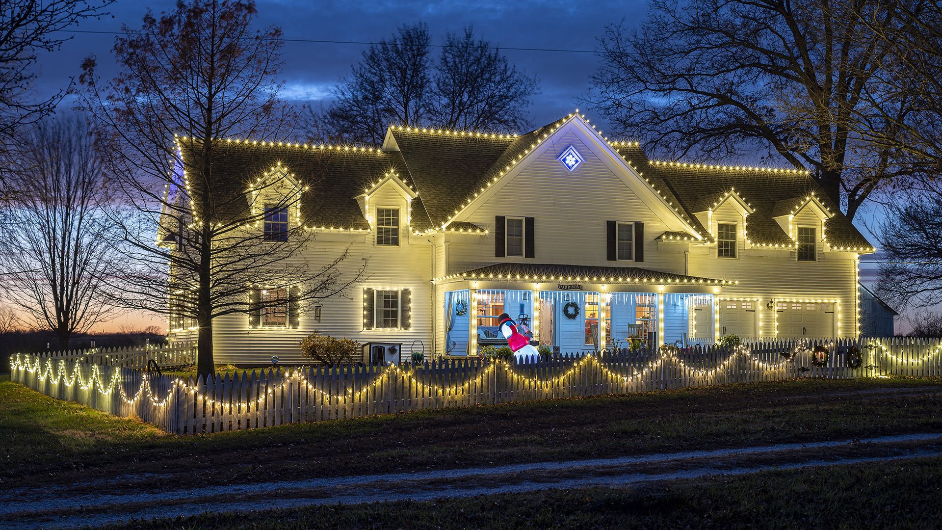 A large house decorated with christmas lights at night