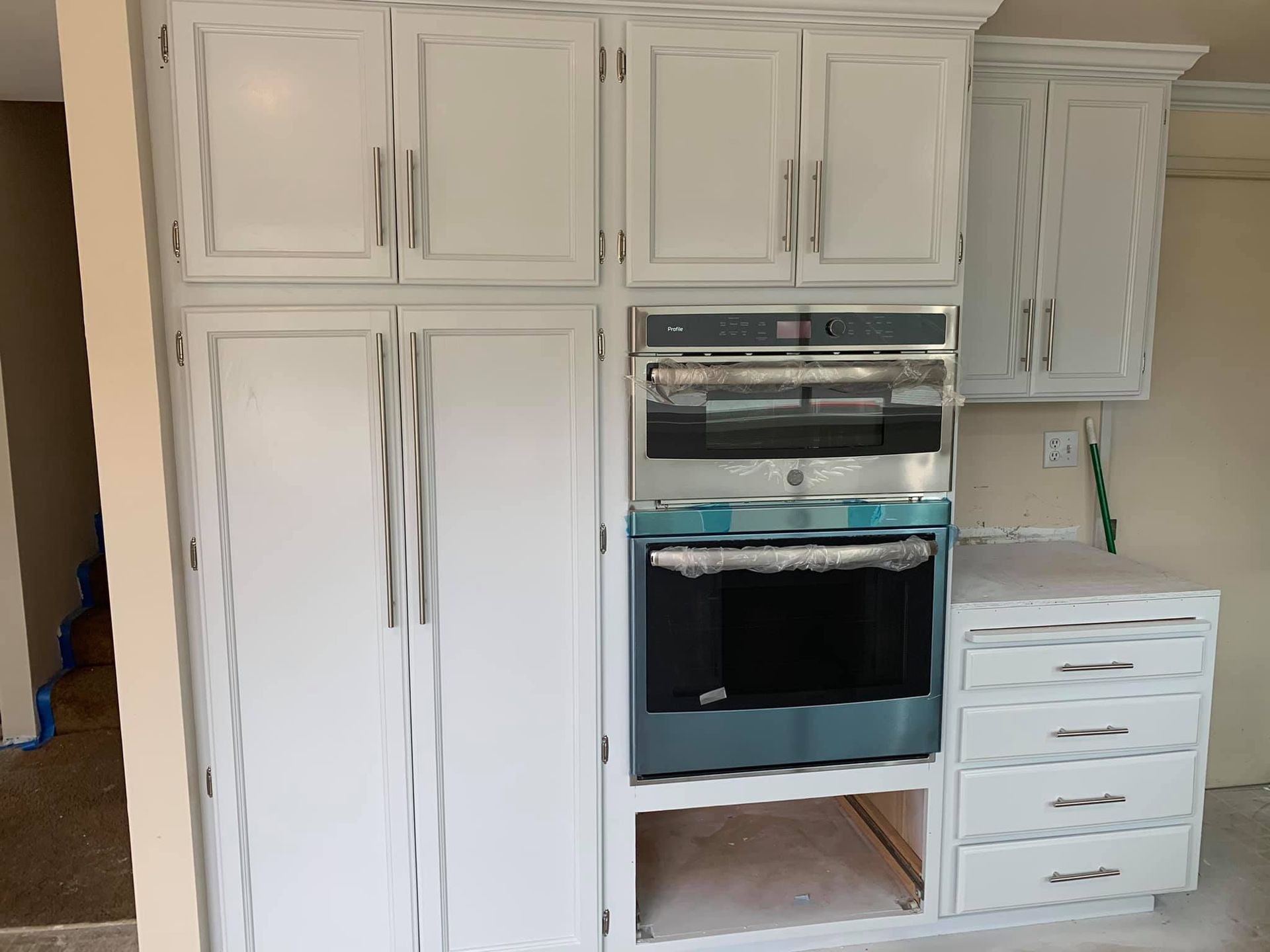 A kitchen with white cabinets and a blue oven