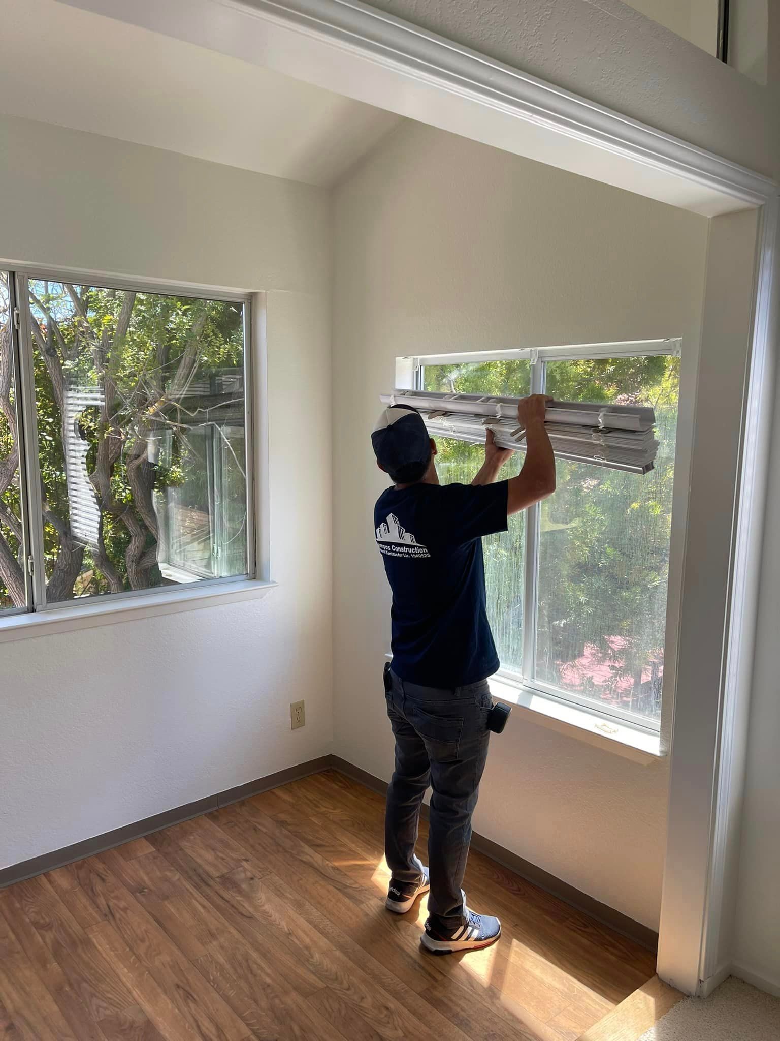 A man is installing a window in a room.