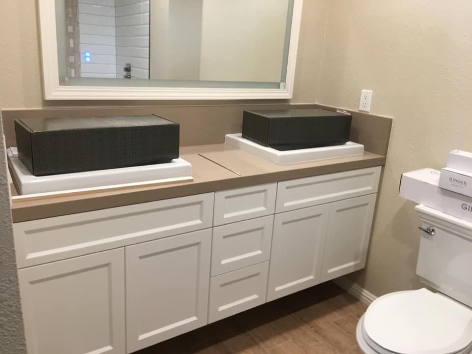 A bathroom with two sinks , a toilet and a mirror.