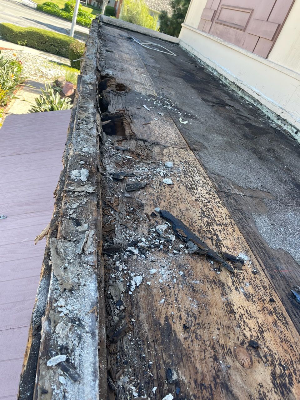 A wooden beam is being removed from the roof of a building.