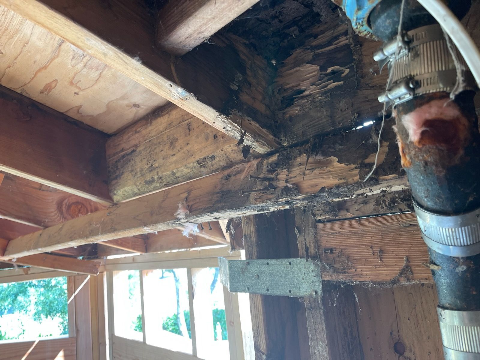 A close up of a wooden structure with a pipe coming out of it.