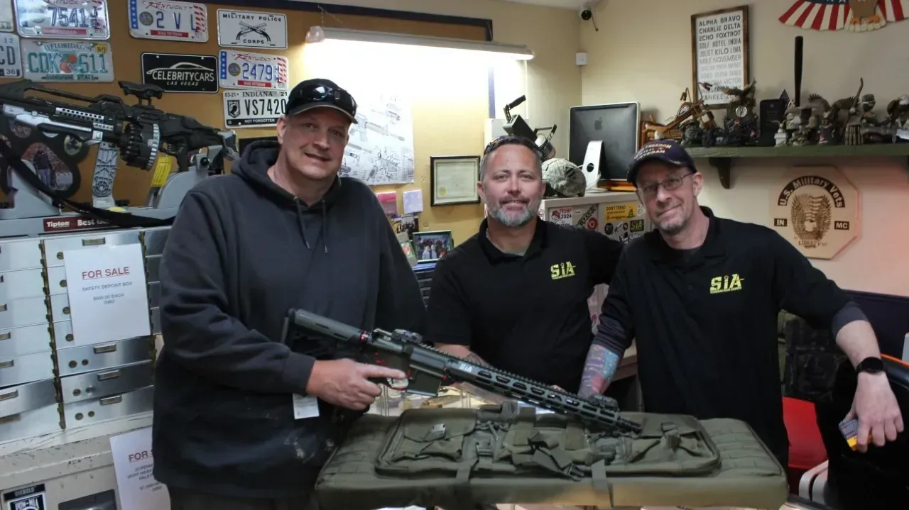 A group of men are standing around looking at a tablet.
