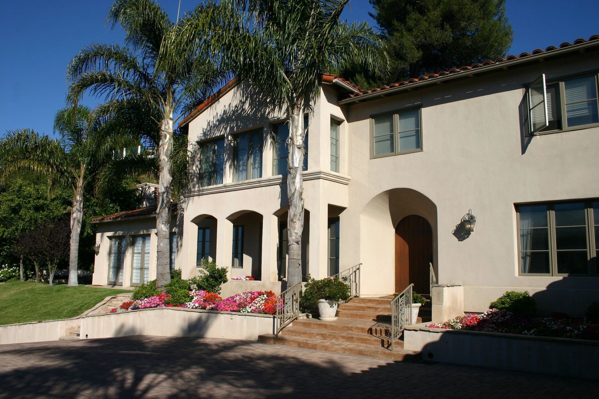 A large white house with palm trees in front of it