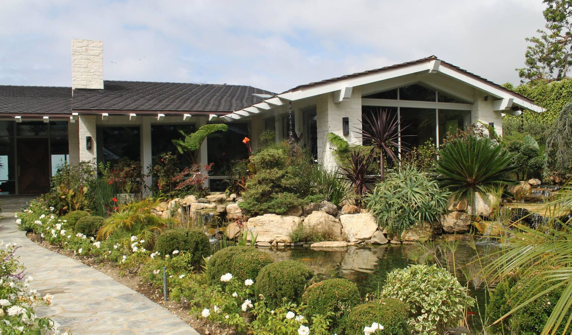 A house with a lot of plants in front of it