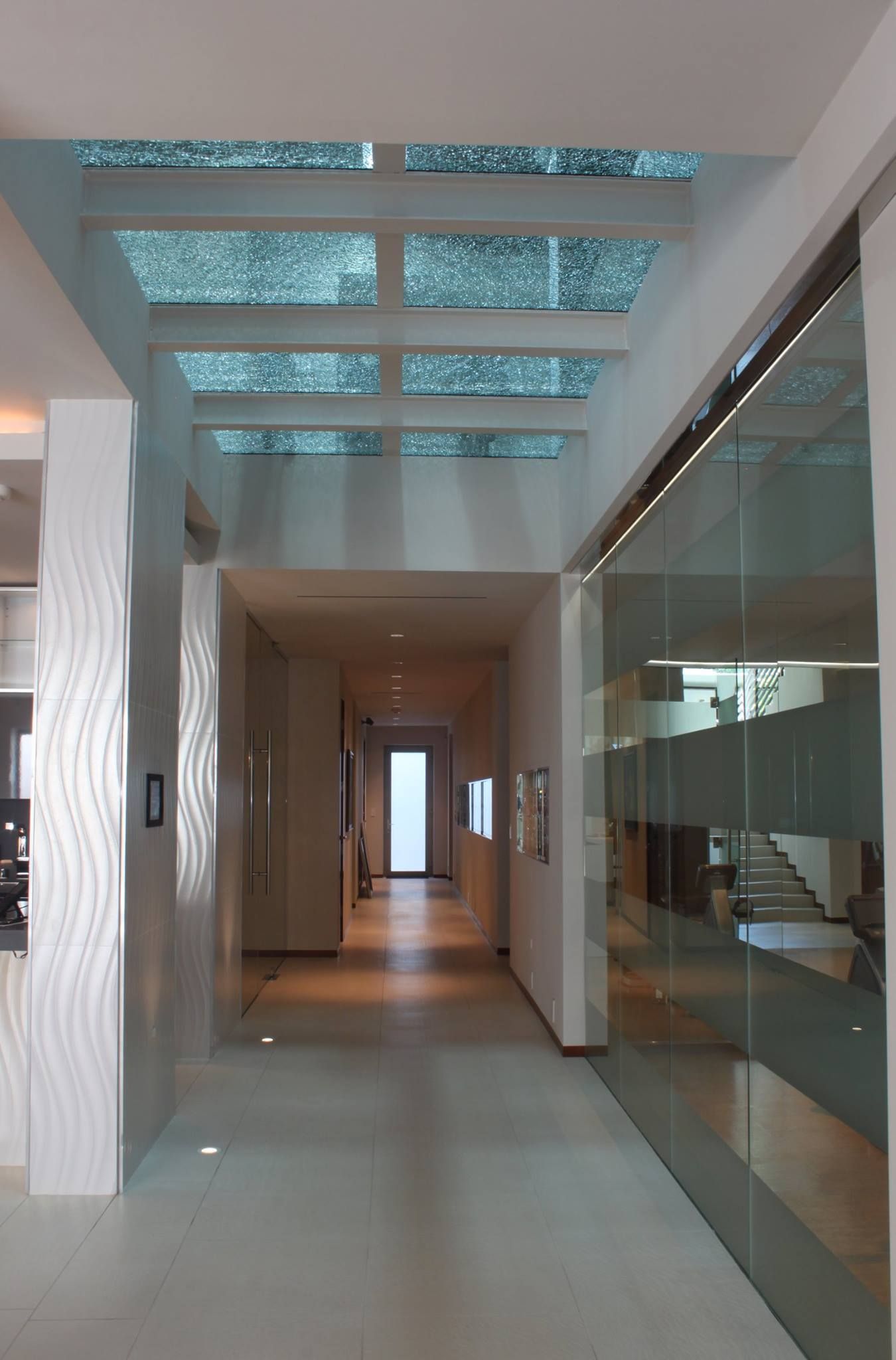 A hallway in a house with a glass ceiling