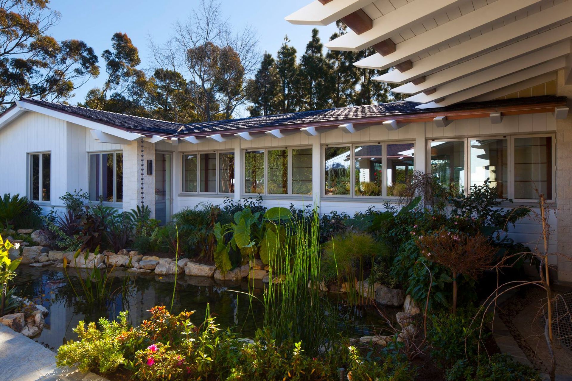 A white house with a pond in front of it