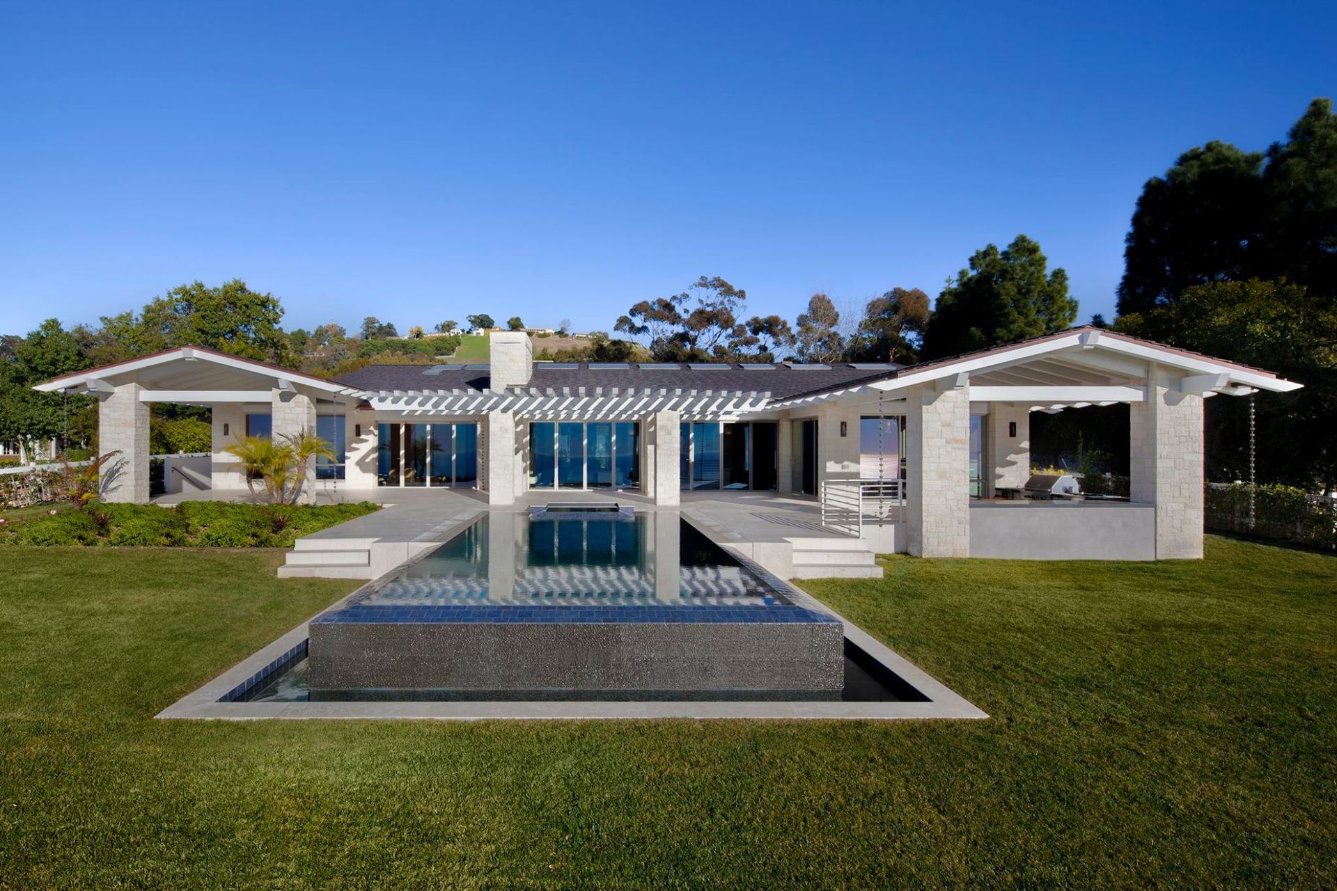 A house with a large swimming pool in front of it