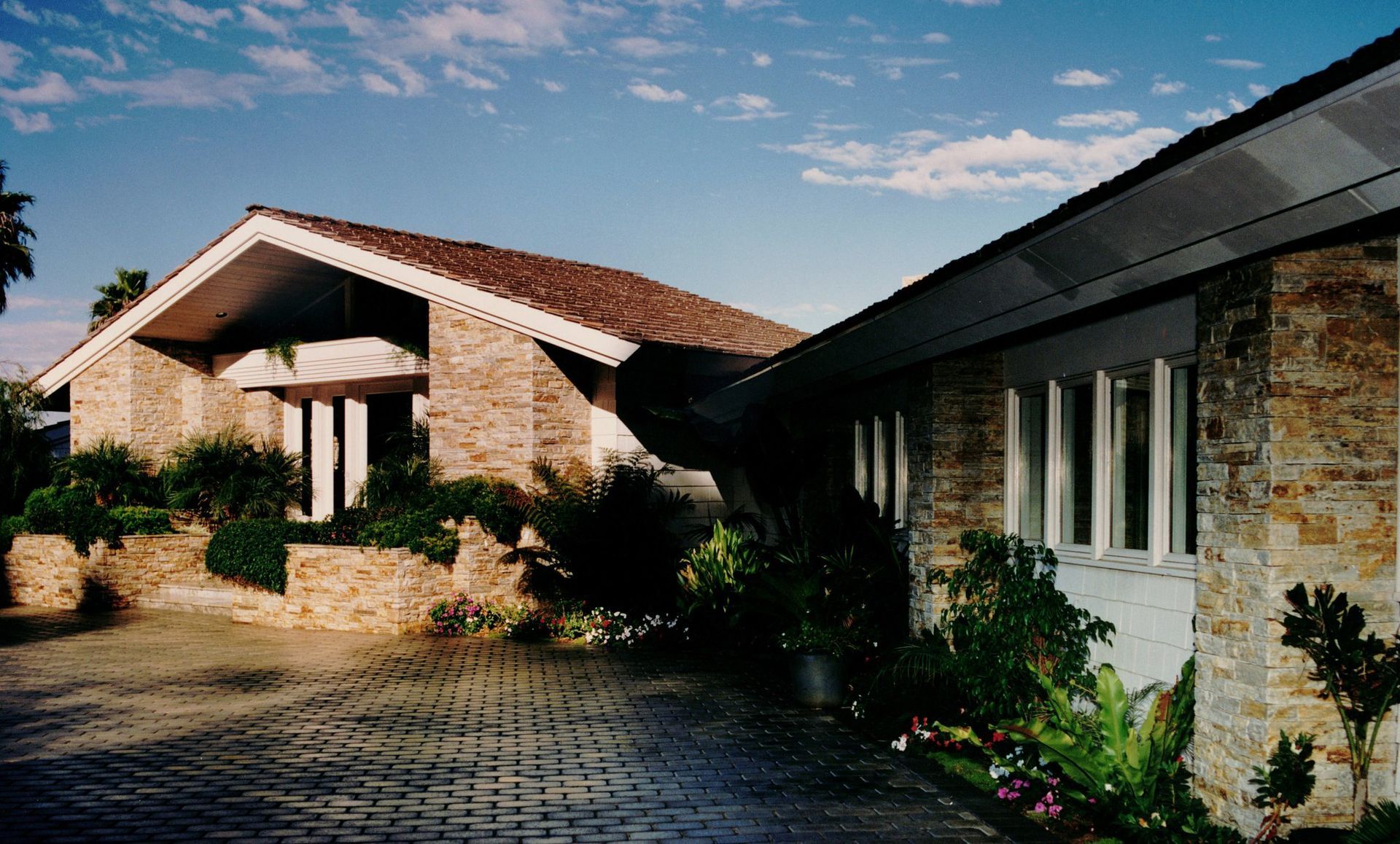 A large brick house with a driveway leading to it
