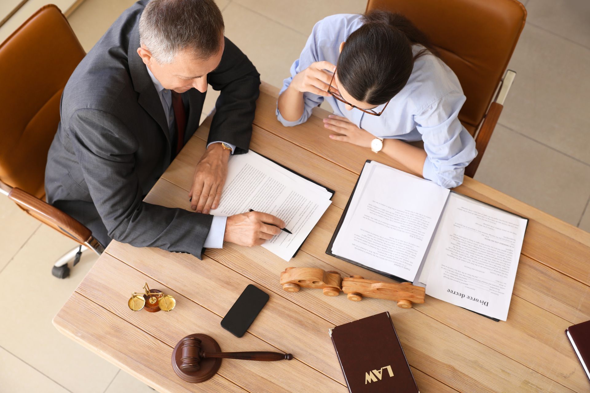 A man and a woman are sitting at a table looking at papers.