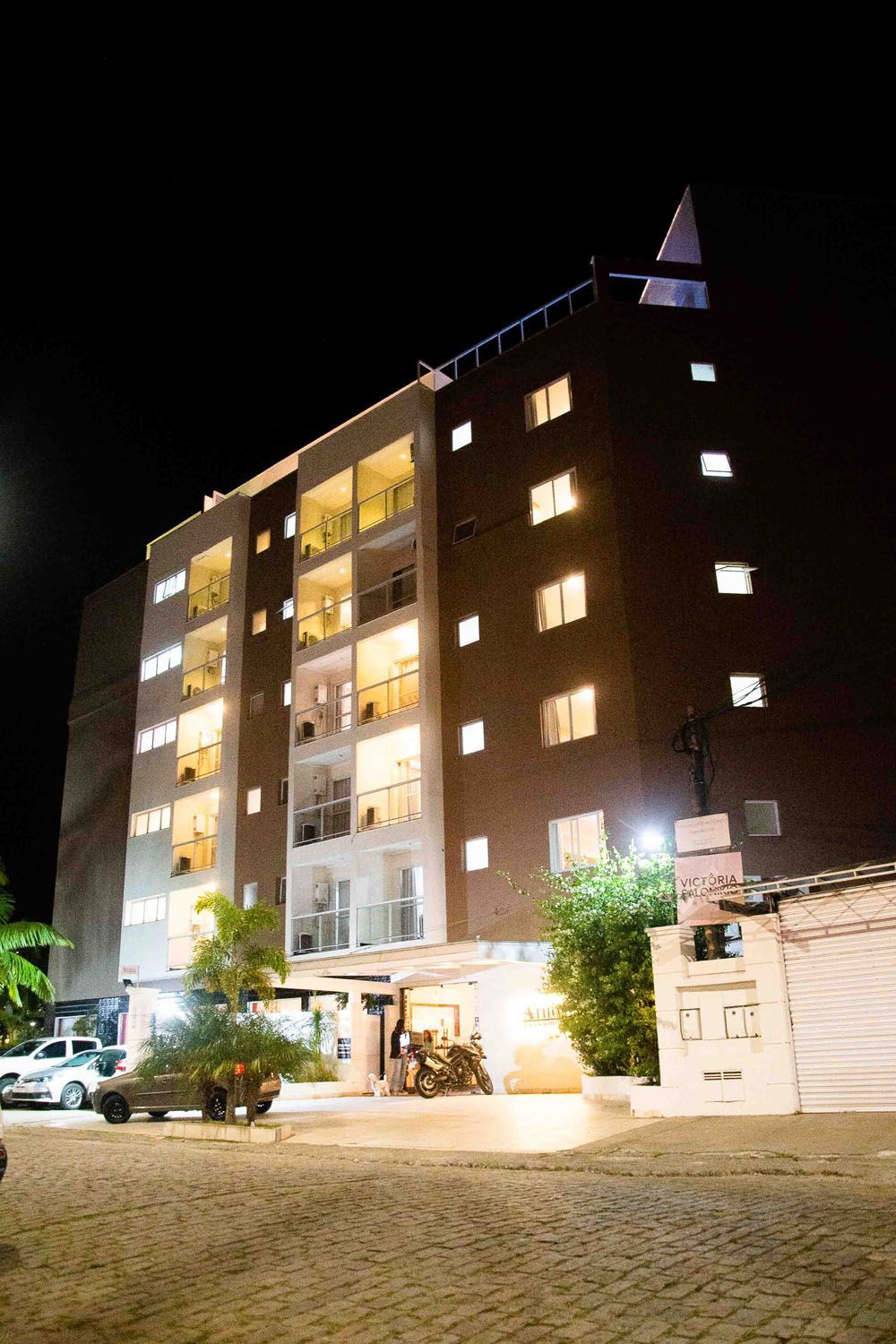 Um grande edifício com muitas janelas fica iluminado à noite.