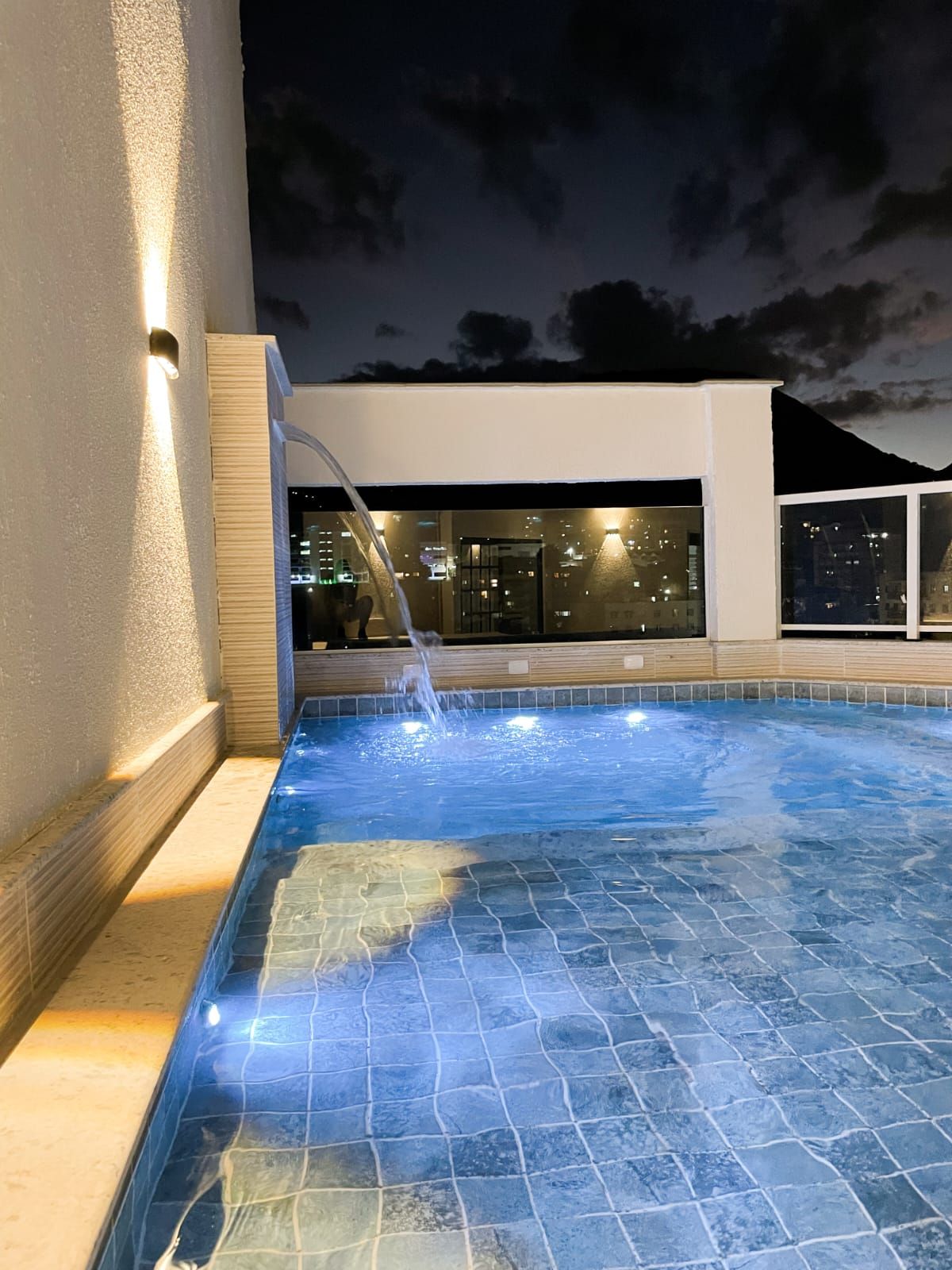 Um quarto de hotel com uma cama grande e piso de madeira.