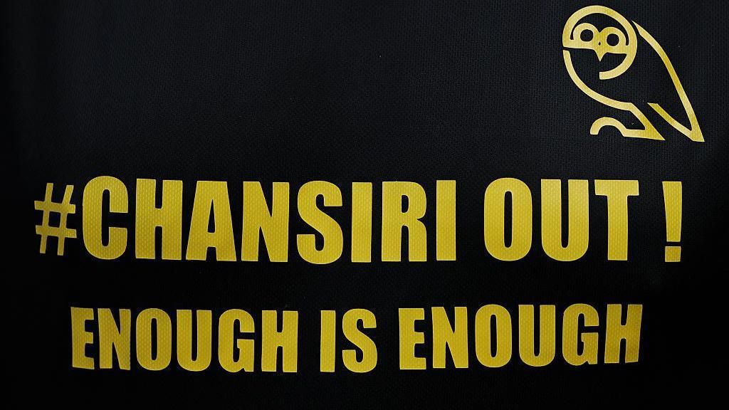Black sign with gold text: 
