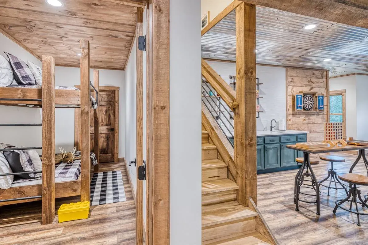 A split view of a rustic interior featuring a bunk bed room on the left and a kitchenette with stairs on the right.