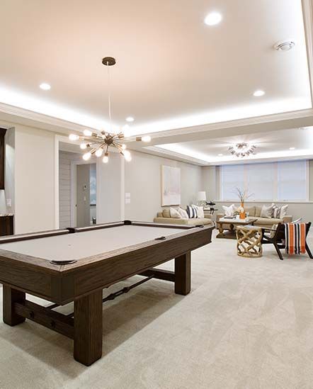 There is a pool table in the middle of a living room.