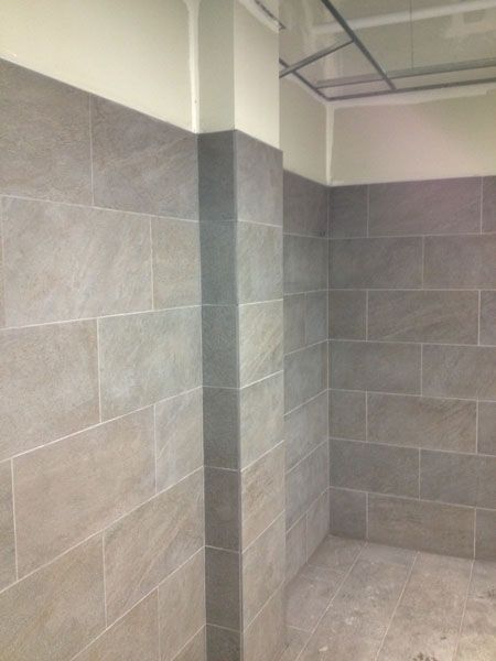 A bathroom with gray tiles and white walls.