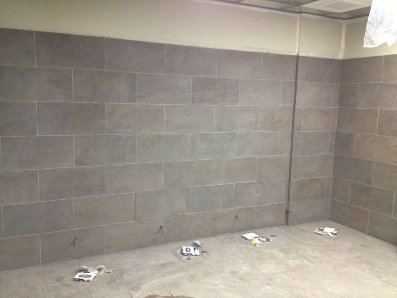 A room with a brick wall and a concrete floor