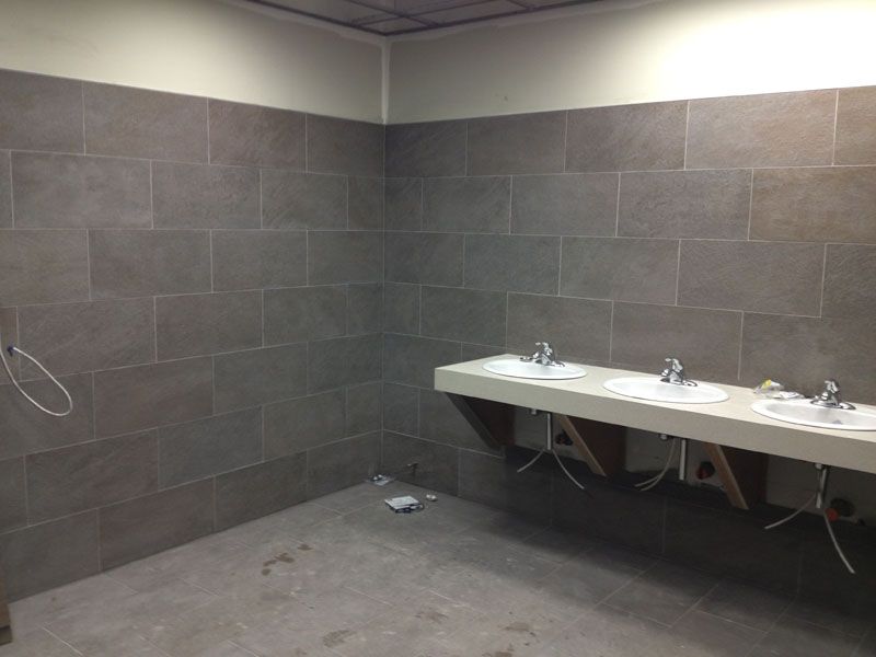 A bathroom with a row of sinks and a shower