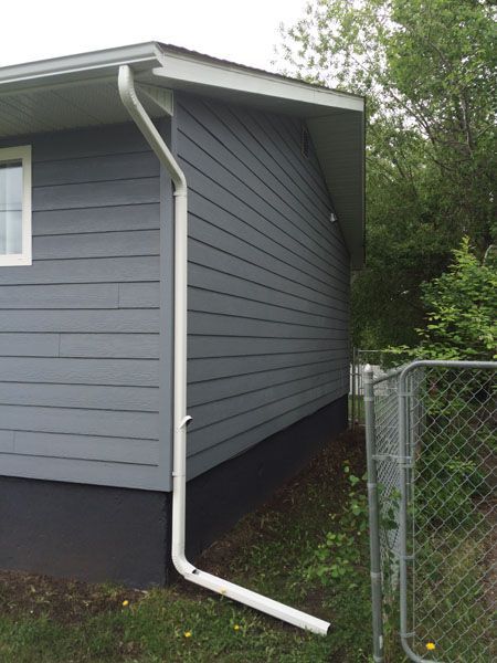 A house with a white gutter on the side of it