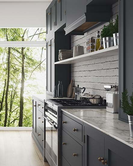 A kitchen with a stove and a window with trees in the background.